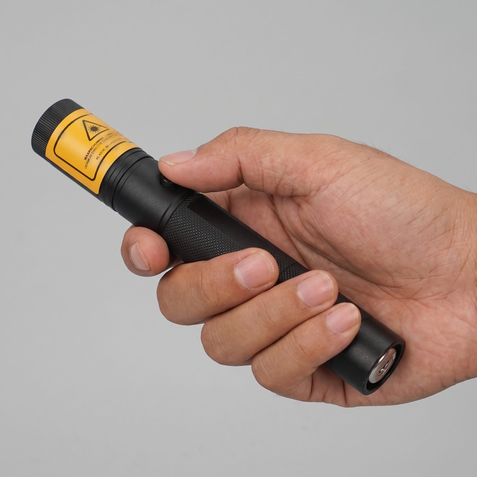 The 50 mW red laser pointer in the hand