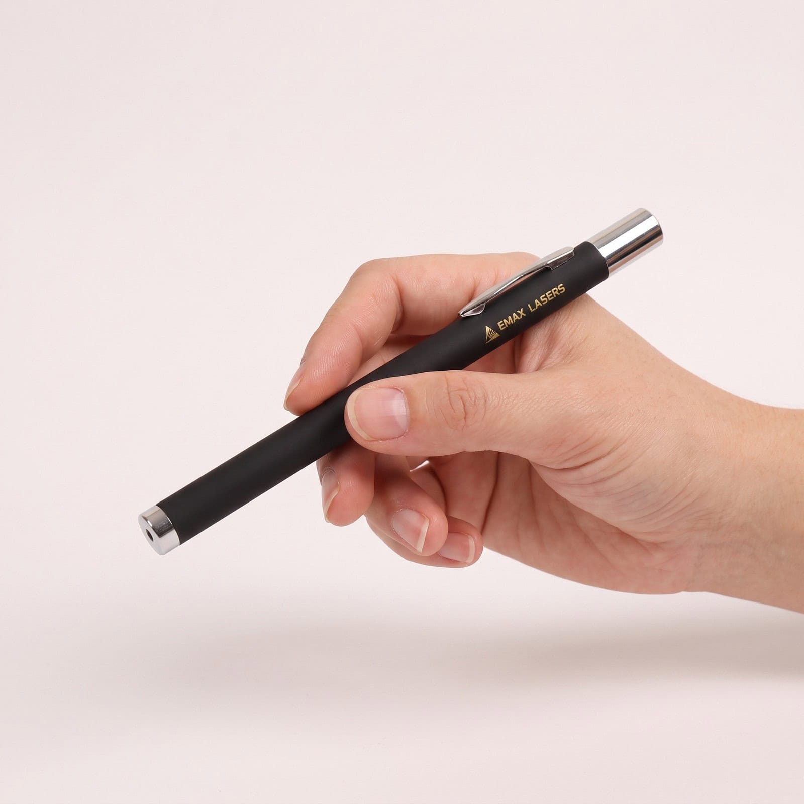 Emax green laser pointer with on/off switch held in the hand, to show the size