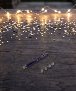 Emax purple laser pointer with five caps in a real setting