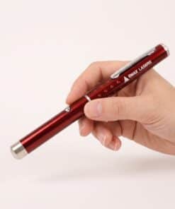 Emax red laser pointer held in the hand, to show the size